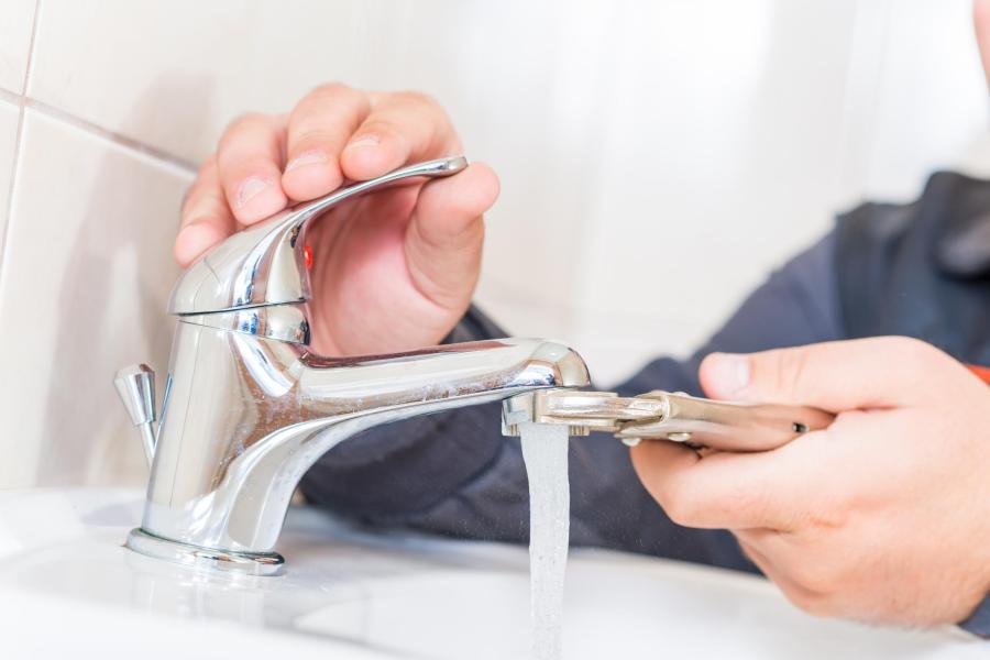 Plumber installing a new sink faucet fixture